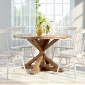 یک میز ناهار خوری گرد چوبی به رنگ قهوه ای با چهار صندلی چوبی سفید و دو گلدان