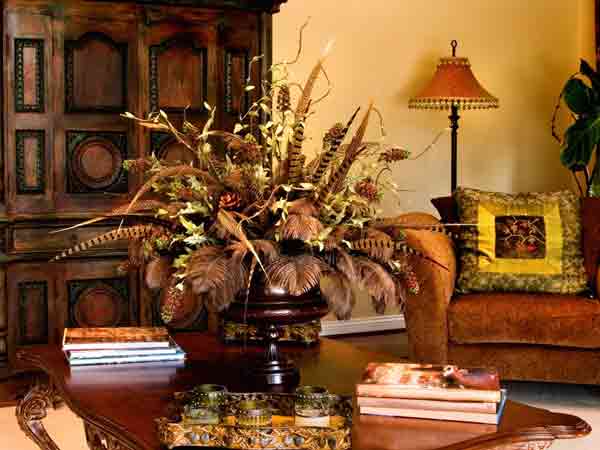 یک گلدان بزرگ با بدنه طرح دار چوبی بر روی یک میز جلو مبلی چوبی قرار گرفته است که کنار آن چندین کتاب بر روی همخ قرار دارند و یک سینی طرح دار همراه با لیوان هایی طرح دار داخل آن بر روی میز جلو مبلی قرار دارد و در این فضای اتاق یک کمد چوبی بزرگ به رنگ قهوه ای سوحتع نیز می باشد و یک مبل راحتی قهوه ای با کوسنی بر روی آن با ترکیب رنگ های سبز و زرد و مشکی می باشد و یک اباژور پشت آن قرار گرفته است