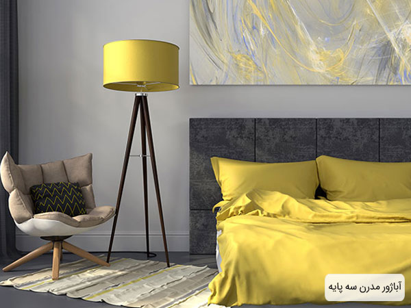آباژور مدرن سه پایه با کلاهک زرد در فضای اتاق خواب با ترکیب رنگ زرد و خاکستری و تابلوی بزرگ نقاشی .