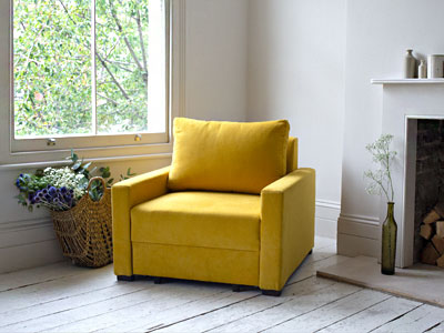 تصویر یک صندلی تختخواب شو زرد رنگ در فضای دکوراسیون منزل در کتار پنجره