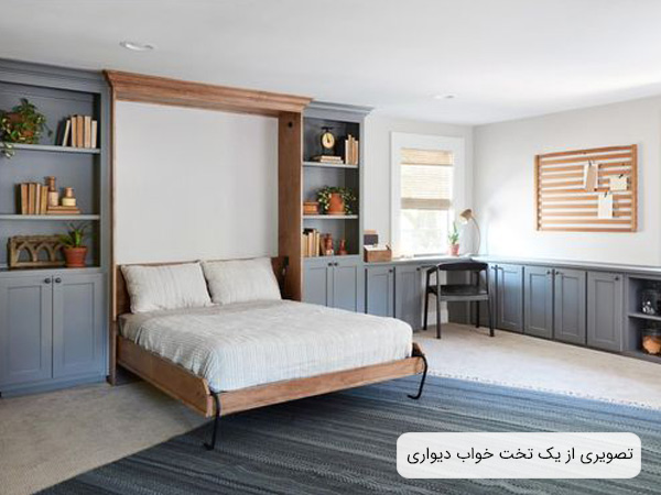 تصويری از يک تختخواب ديواری تاشو به رنگ قهوه ای روشن و قفسه هايی به رنگ خاکستری و تعدادی از لوازم دکوری که در قفسه ها قرار گرفته اند.