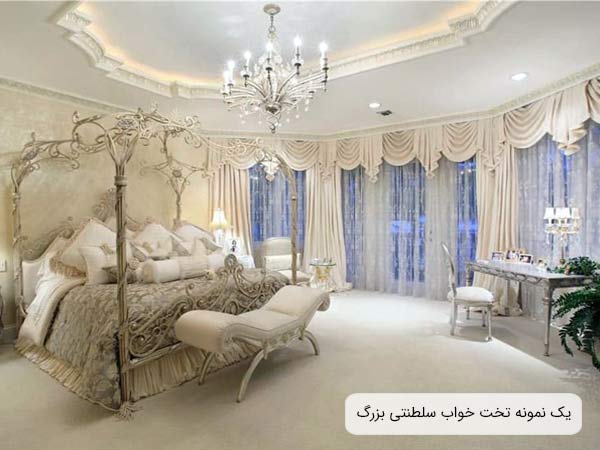 تصويری از يک تخت خواب سلطنتی با سايز بزرگ و به رنگ سفيد و ستون دار که ظاهر بسيار لوکس و شيکی داشته و در يک اتاق با طراحی کلاسيک و زيبا قرار گرفته است.