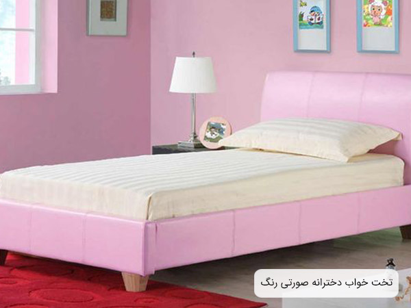 تصويری از يک تخت خواب دخترانه ساده صورتی رنگ در اتاق خوابی با ديوار های صورتی.
