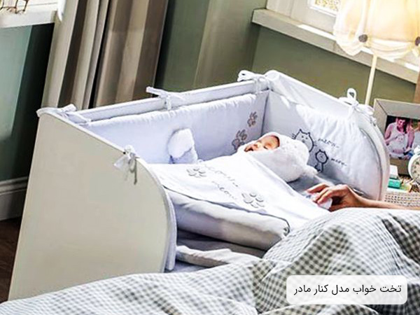 تصويري از تخت خواب نوزاد مدل کنار تختی که يک نوزاد در اين تخت خوابيده است و مادرش بر روي تخت خود در کنار اين نوزاد مي باشد.