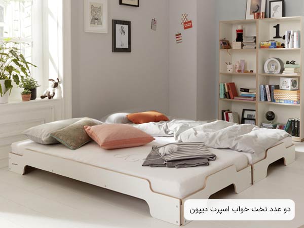 تصويري از دو عدد تخت خواب ديپون a26 به رنگ سفيد در کنار هم که در مرکر يک اتاق قرار گرفته اند.