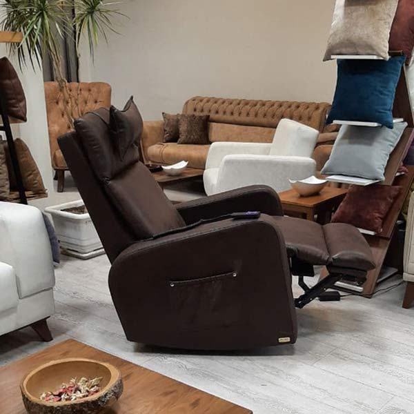 صندلی تختشو برقی با رنگ قهوه ای به همراه يک کنترل در اتاقی با دکوراسيون مدرن.