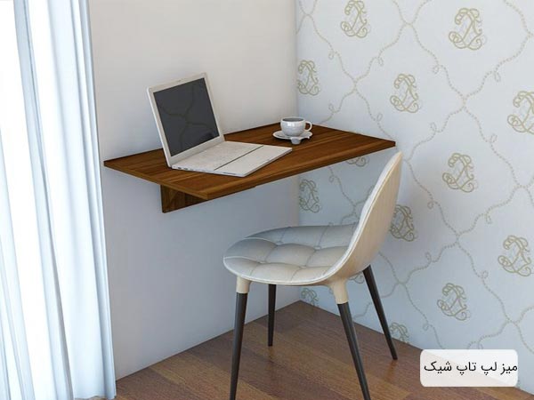 ميز تحرير مدرن و شيک غزال با طراحی ساده به رنگ قهوه ای که يک عدد لپ تاپ بر روی آن قرار گرفته در کنار يک صندلی تحرير.