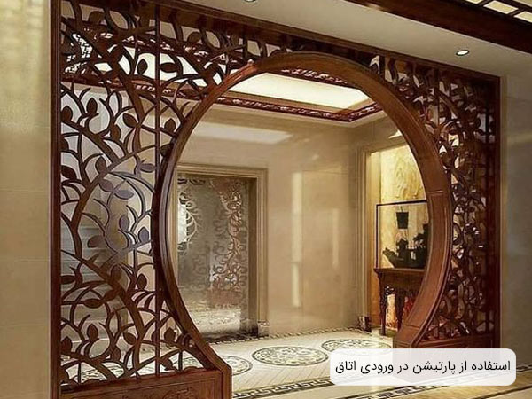پارتيشن چوبي بزرگ طرحدار نصب شده در ورودي يک اتاق به رنگ قهوه اي روشن.