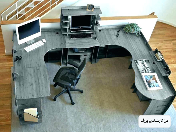اتاق یک اداره با فضای محدود که دارای یک میز کار اشتراکی با صندلی های اطرافش است با دکوراسیون ساده و مینیمال.