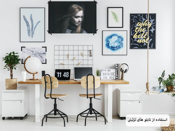 یک دفتر کار خانگی با دکوراسیون مدرن و ترکیب رنگ روشن و تابلو های دیواری متعدد.
